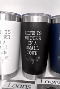 coffee mugs on display at The Bookstore in Pine City that say Life is Better in a Small Town.